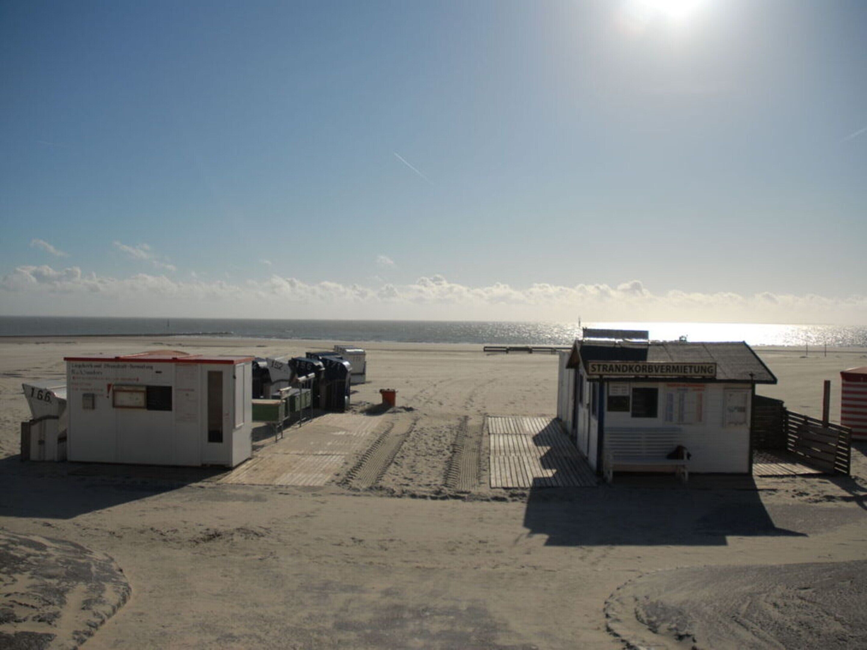 A beachside building with a sign reading "Strandkorbevermietung".