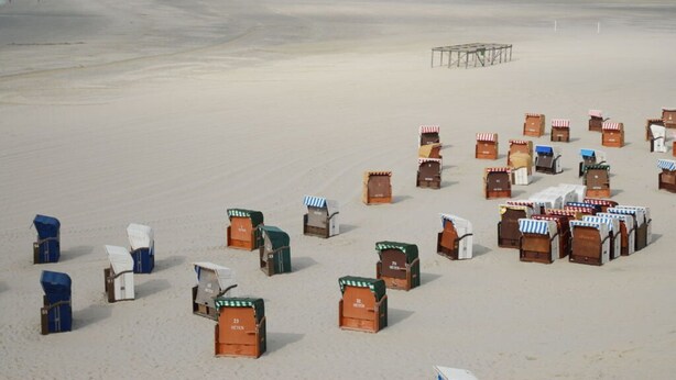 A beach with numerous small, colorful beach huts arranged in rows. - - 2 min zum Strand (Borkum)