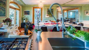 Een moderne keuken met een centraal eiland, roestvrijstalen apparatuur en een eethoek met een tafel gedekt voor vier personen.