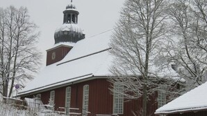 Um edifício coberto de neve com uma torre imponente e um relógio.