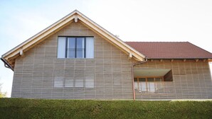 A two-story house with a sloped roof and a small balcony. - Nice Apartment in Diessen (Dießen am Ammersee)