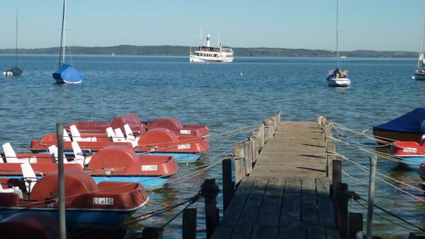 A dock with several small boats and a larger ferry in the background. - Nice Apartment in Diessen (Dießen am Ammersee)