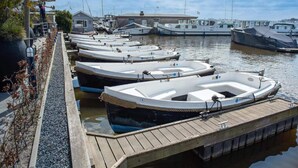 A marina with several small boats docked at wooden piers. - Loosdrecht Water Villa (Loosdrecht)