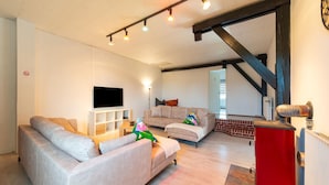 A modern living room with two sofas, a flat-screen TV, and a red cabinet. - Pet Friendly Villa in Elsenborn (Buetgenbach)