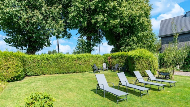 A well-maintained outdoor area with lounge chairs and a hedge. - Pet Friendly Villa in Elsenborn (Buetgenbach)