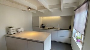 Eine moderne Küche mit Kochinsel, integrierten Geräten und einem Fenster mit Blick.