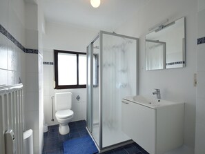 Un baño con inodoro, ducha y lavamanos.