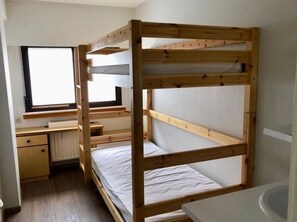 Dormitorio con literas, escritorio y ventana.