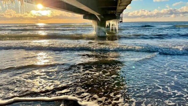 A pier extending into the water with a sunset in the background. - Our-island-scharbeutz (Scharbeutz)