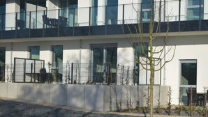 A modern building with large windows, a gravel driveway, and a small tree. - High End Travemunde Comfortable Vacation Home (Lübeck)