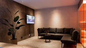 Un salon moderne avec un canapé, une table basse et un téléviseur fixé au mur.