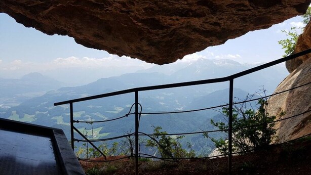 A rocky overhang with a metal railing overlooking a mountainous landscape. - Uitzicht op Staufen (Piding)
