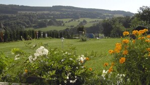 Een landelijk landschap met een helder uitzicht op glooiende heuvels en een afgelegen huis.