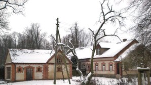 A two-story building with a snow-covered roof and brick walls. - in the Estate Worker's House (Karstädt)