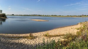 Un río con orillas de arena y vegetación escasa.