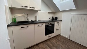 A compact kitchen with a skylight, a sink, a stove, and cabinets. - Spacious Holiday Home Near Ski-lift (Todtmoos)
