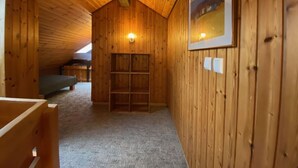 A wooden interior with a sloped ceiling, a framed picture on the wall, and a built-in bench. - Spacious Holiday Home Near Ski-lift (Todtmoos)