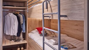 A bunk bed with a wooden headboard, a wardrobe with hanging clothes, and a shelf with shoes. - Comfortable Apartment With air Conditioning (Bruges)