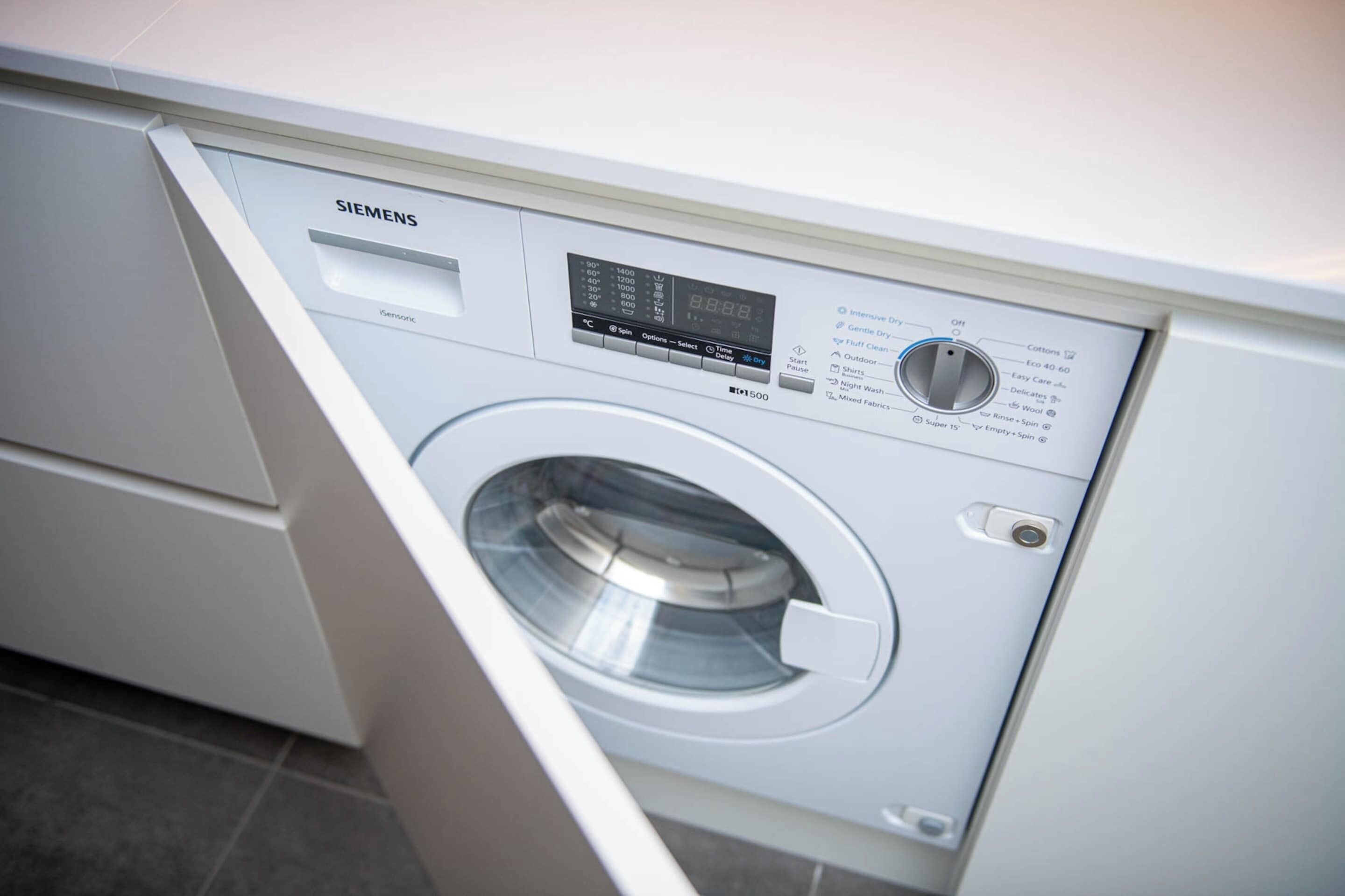Een Siemens wasmachine met een digitaal scherm, bedieningspaneel en een voorlaadklep.