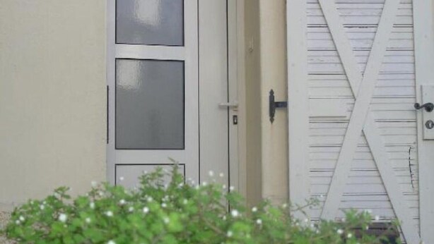 A white door with a frosted glass panel and a white garage door with a diagonal brace. - Apartment Regina - Duplex Two Bedroom Apartment (Split)