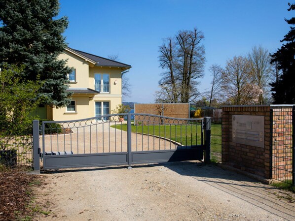 A gated entrance to a residential building with a paved driveway leading to the entrance. - Casa sul Lago Modern Retreat (Werder (Havel))