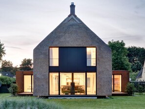 A modern two-story house with a steeply pitched roof, large windows, and a well-maintained lawn. - Seestuck Prerow (Ostseebad Prerow)