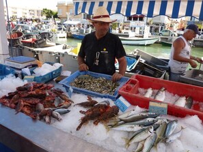 A seafood market with various fish displayed on ice, including lobsters and mackerel. - Villa des Cigales (Oberrieden)