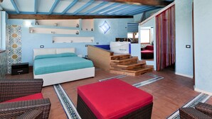 A bedroom with a bed, a desk, a chair, and a staircase leading to a balcony.