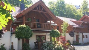 A wooden chalet with a balcony, surrounded by a gravel driveway and landscaped garden. - Carl-lambrecht-chalet No. 19 (Ilsenburg)