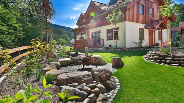 A large, two-story wooden house with a well-maintained garden and a wooden fence. - Carl-lambrecht-chalet No. 19 (Ilsenburg)