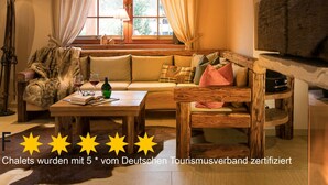 A cozy room with a wooden sofa, a table with a bottle and glasses, and a window with curtains. - Carl-lambrecht-chalet No. 19 (Ilsenburg)