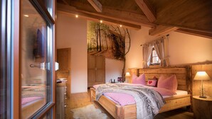 A cozy bedroom with a wooden bed, a large mirror, and a rustic ceiling. - Carl-lambrecht-chalet No. 19 (Ilsenburg)