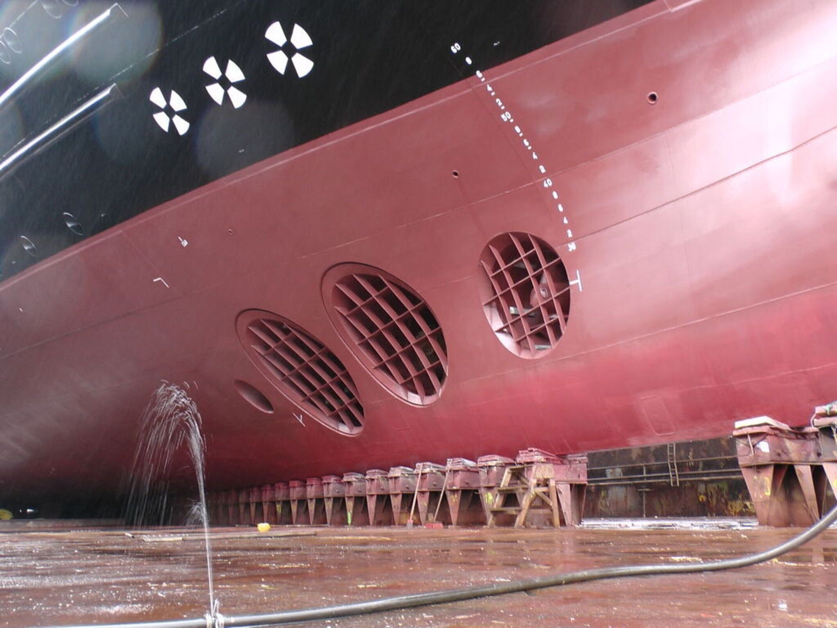 A large ship with three circular ventilation ports and a water jet cleaning system.