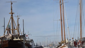 A marina with several tall sailing ships docked. - Apartment Newport Weser (Bremerhaven)