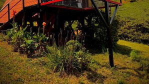 Una casa con techo rojo, paneles solares y baranda roja.