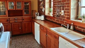 A kitchen with wooden cabinets, a sink, and a toaster. - Nice Apartment in Weilmunster (Weilmünster)