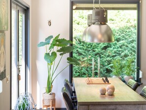 A dining area with a wooden table, chess set, and a hanging pendant light. - Peaceful Nature Escape in Meijel (Meijel)