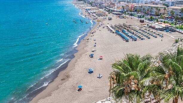 A coastal cityscape with a wide beach, rows of beach umbrellas, and a clear blue sea. - Belvilla by OYO Casa El Pinar (Torremolinos)