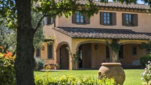 A two-story building with a tiled roof, arched doorways, and a well-maintained garden. - Villa Miniato Comfortable Holiday Residence (San Miniato)