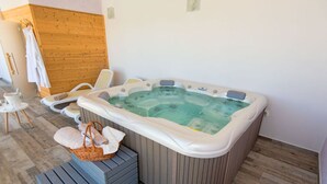 A spa room with a hot tub, lounge chairs, and a wooden wall. - New White Villa, 60 m2, Pool (Vodnjan)