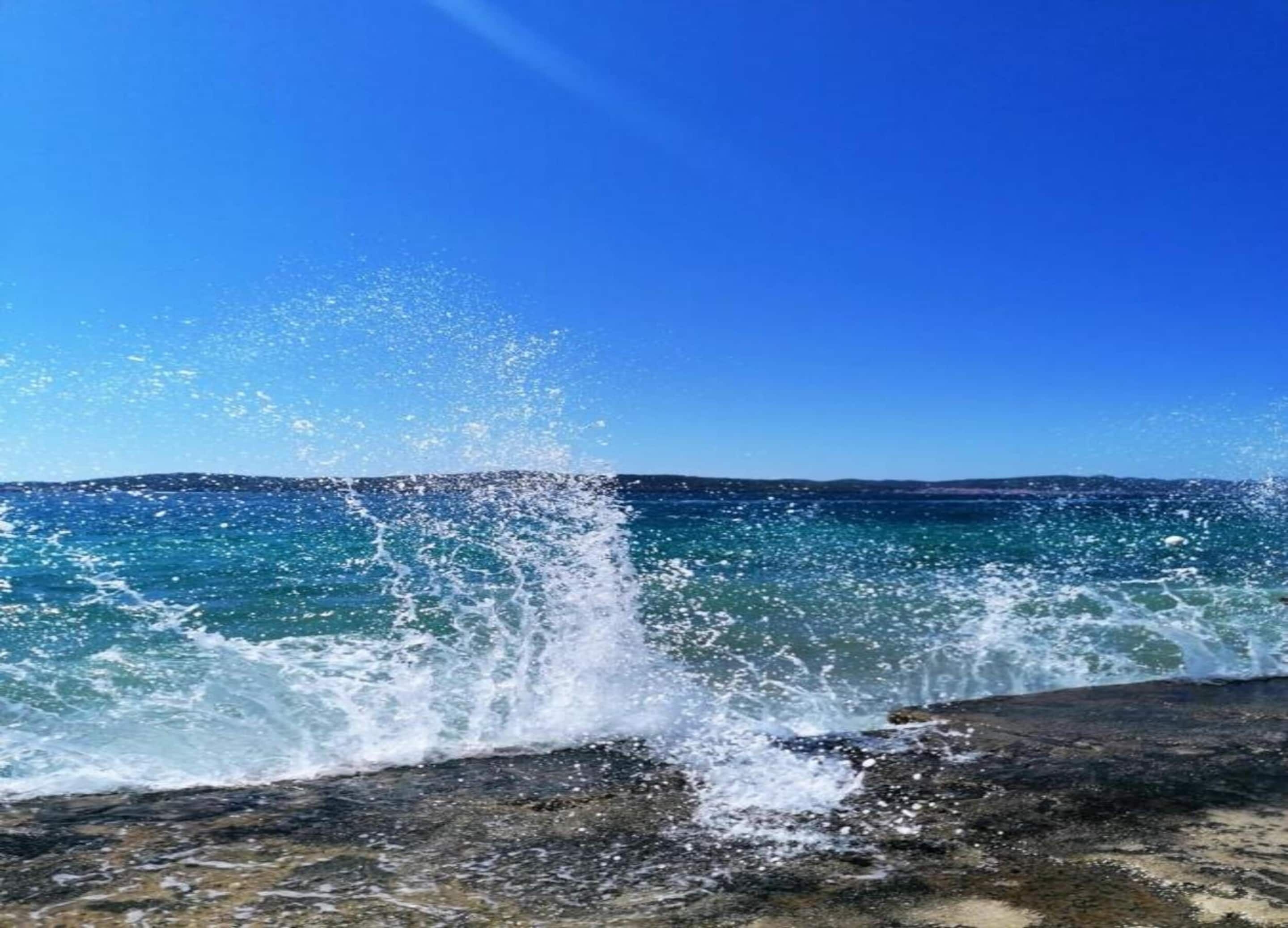 A rocky shoreline with waves crashing against it.