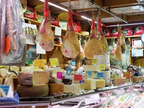 A cheese shop with various types of cheese displayed on shelves and hanging from hooks. - Belvilla by OYO Casa Rosolina Due (Ariano nel Polesine)