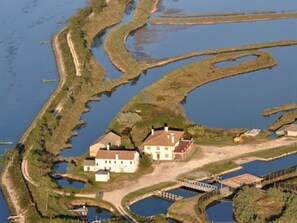 A coastal property with a large house, a dock, and a series of water channels. - Belvilla by OYO Casa Rosolina Due (Ariano nel Polesine)