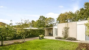 A residential backyard with a lawn, a small garden area, and a shed. - Huijsmans Verhuur Type A de Luxe Grevelingen 29 (Ouddorp)
