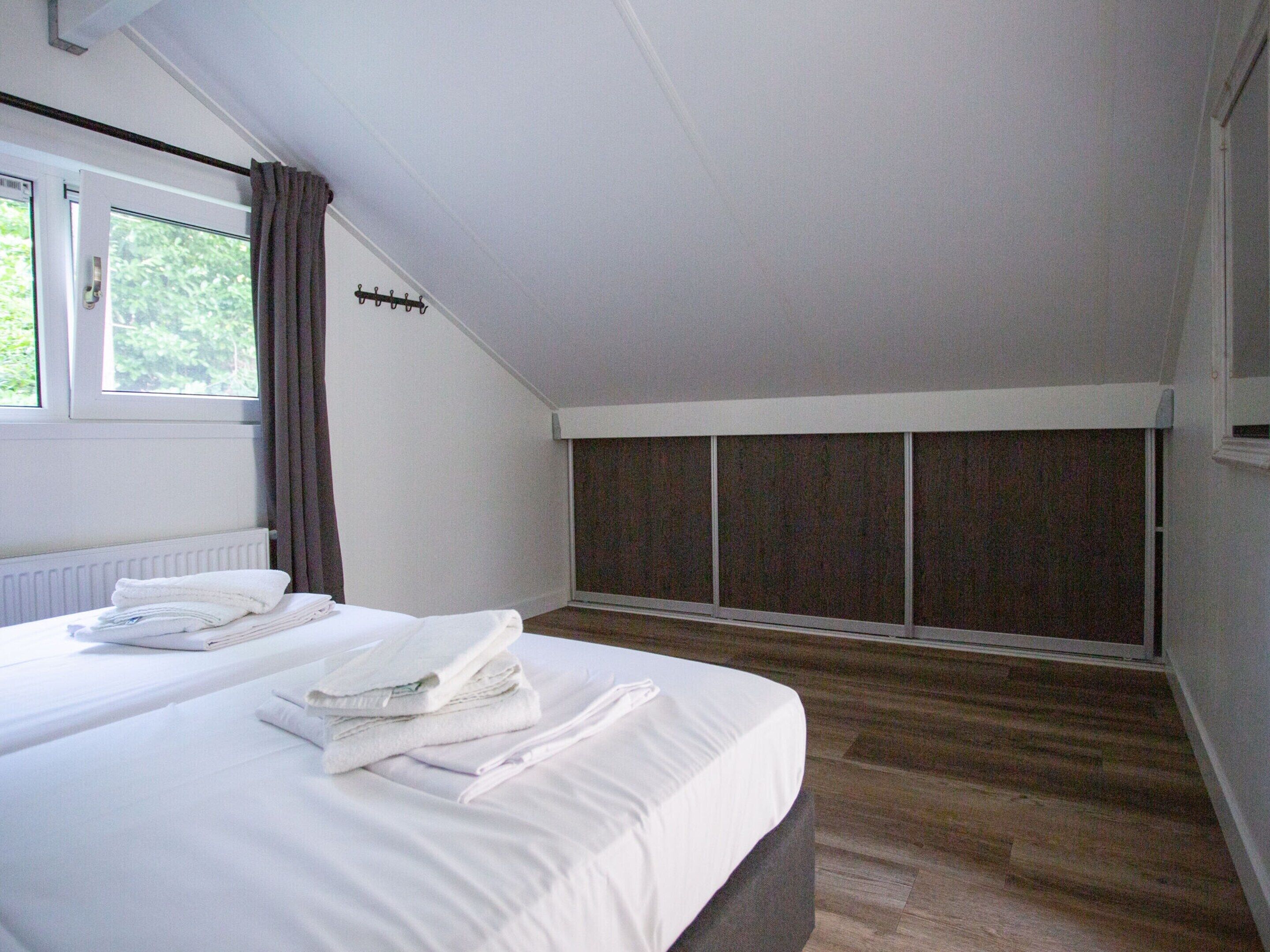 A bedroom with a bed, a window, and a wardrobe.