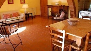 A cozy living room with a tiled floor, a sofa, a coffee table, and a dining table with chairs. - Spacious Tuscan Villa Retreat (Palaia)