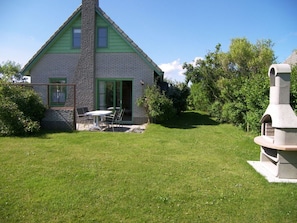 A house with a green roof, a brick exterior, and a patio with a table and chairs. - Beach Pearl Julianadorp (Julianadorp)