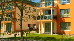 A multi-story residential building with balconies, large windows, and a well-maintained lawn. - Beach Dune 18 on the Beach (Karlshagen)