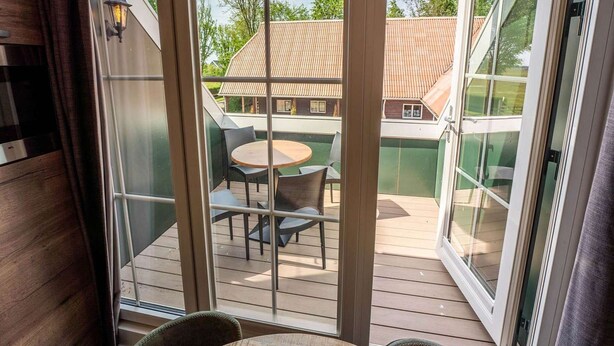 A room with a sliding glass door leading to an outdoor deck with a table and chairs. - Nice Apartment on Ameland With Balcony/terrace (Buren)