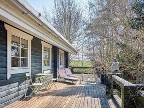 A wooden deck with lounge chairs and a table, overlooking a natural landscape. - 6 Person Holiday Home in Ronne (Ronne)